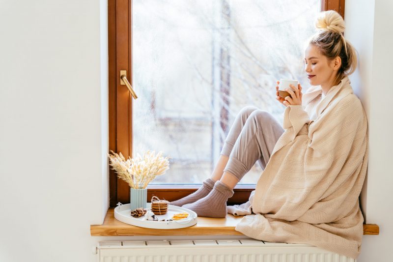 woman drinking tea on window ledge